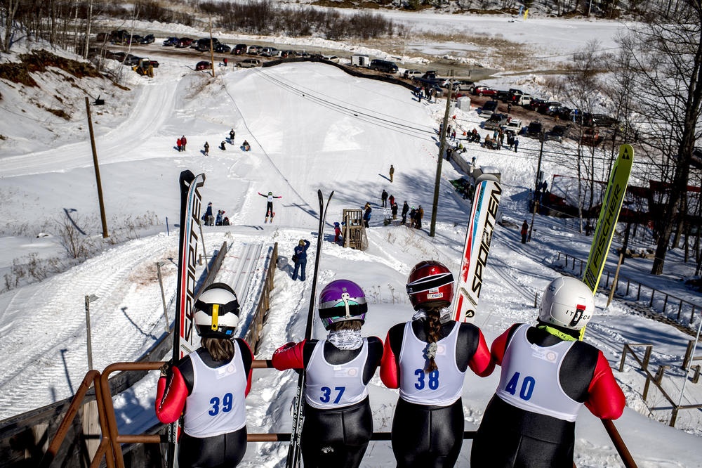 Ski jumpers watch a competitor jump the 25-meter ski jump during the 134th annual ski jumping tournament at the Suicide Hill Ski Bowl in Ishpeming, Mich. on March 6, 2021.