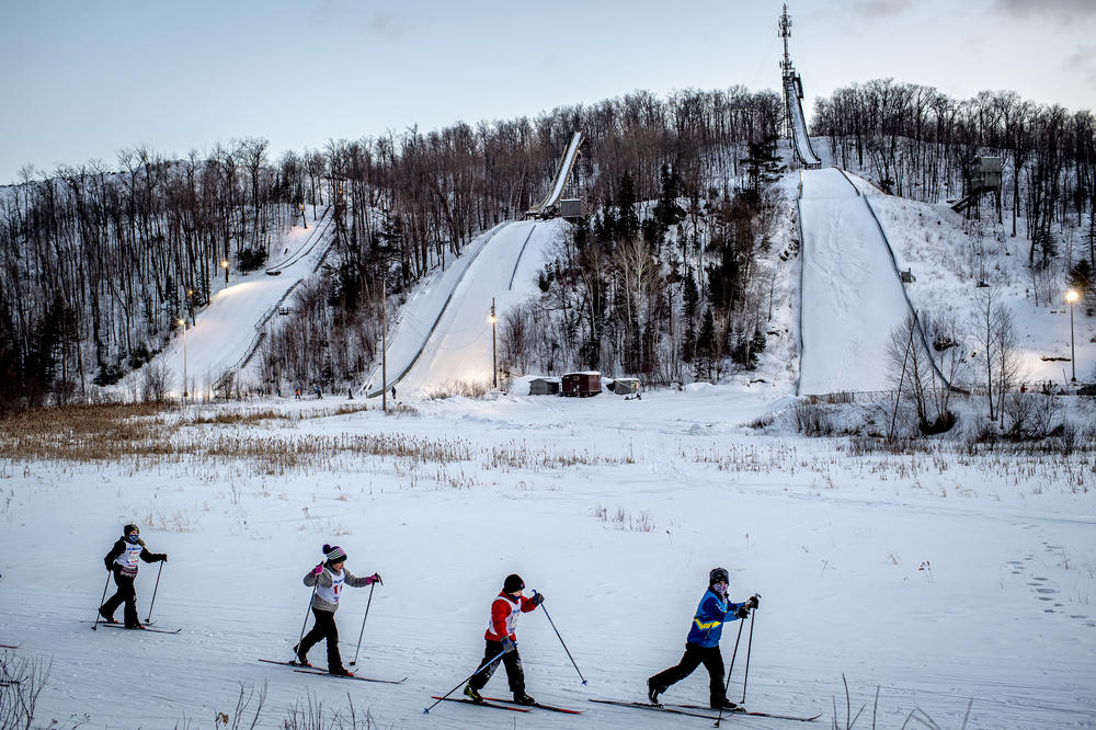 Cross-country skiers slide past the Suicide Hill Ski Bowl during an Ishpeming Ski Club practice in Ishpeming, Mich. on March 3, 2021. Many of those who ski jump also cross-country ski. The Olympic winter sport Nordic Combined integrates the two sports of ski jumping and cross-country skiing.