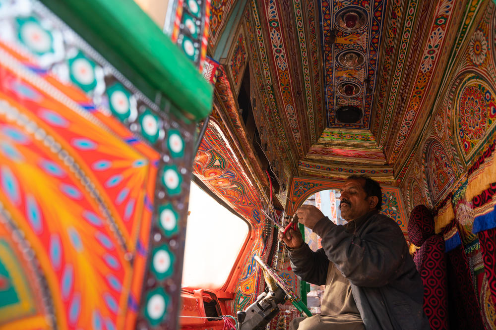 Electrician Muhammad Ishaq, 50, works on a series of lights for the front of a truck.