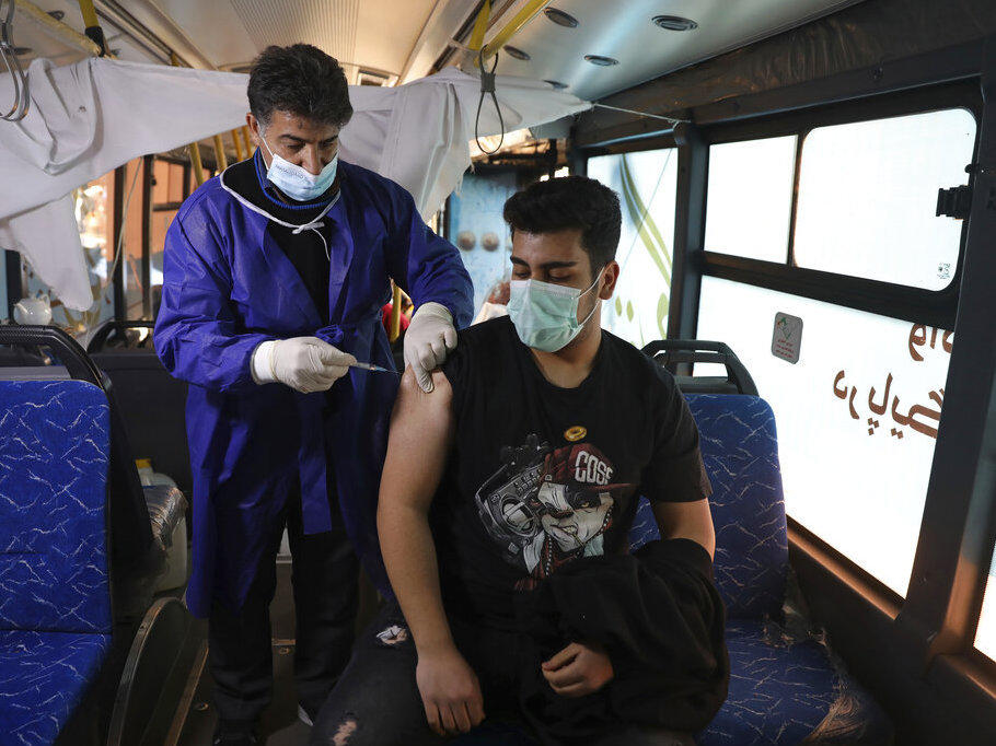 A man receives a COVID-19 vaccine at a mobile vaccine clinic bus at the Grand Bazaar of Tehran, Iran, Saturday, Jan. 22, 2022.