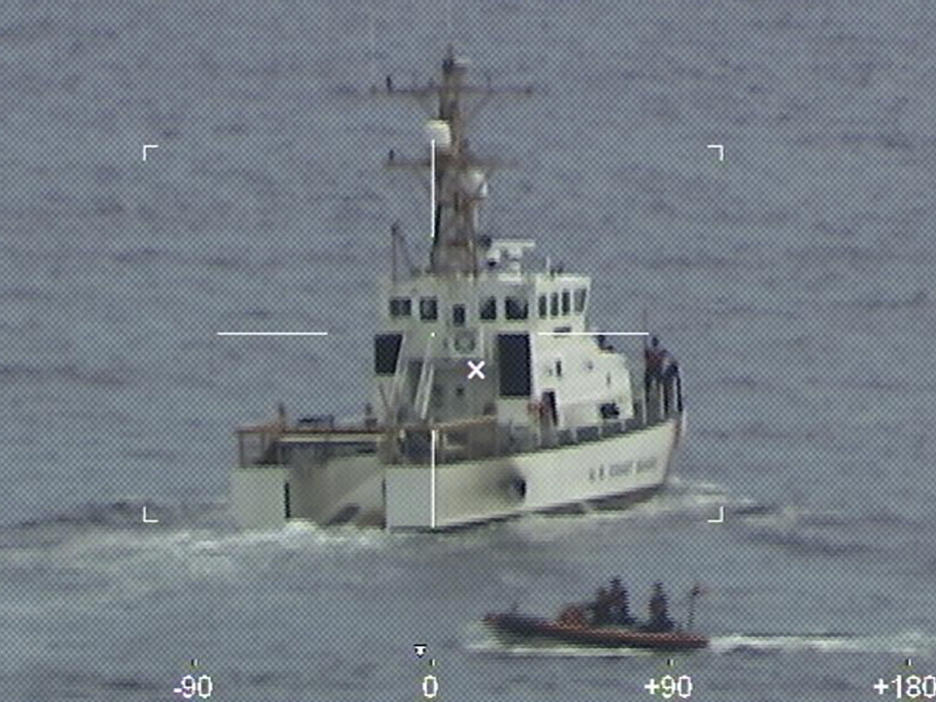 The crew of the Coast Guard Cutter Ibis' searches for people missing from a capsized boat off the coast of Florida on Tuesday.