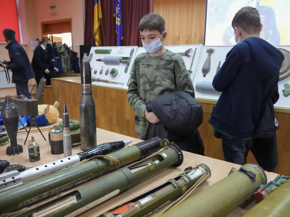 Schoolchildren look at explosives during a police-organized civilian safety lesson in a city school in Kyiv, Ukraine, on Thursday. City authorities have launched training for civilians amid fears about a Russian invasion.