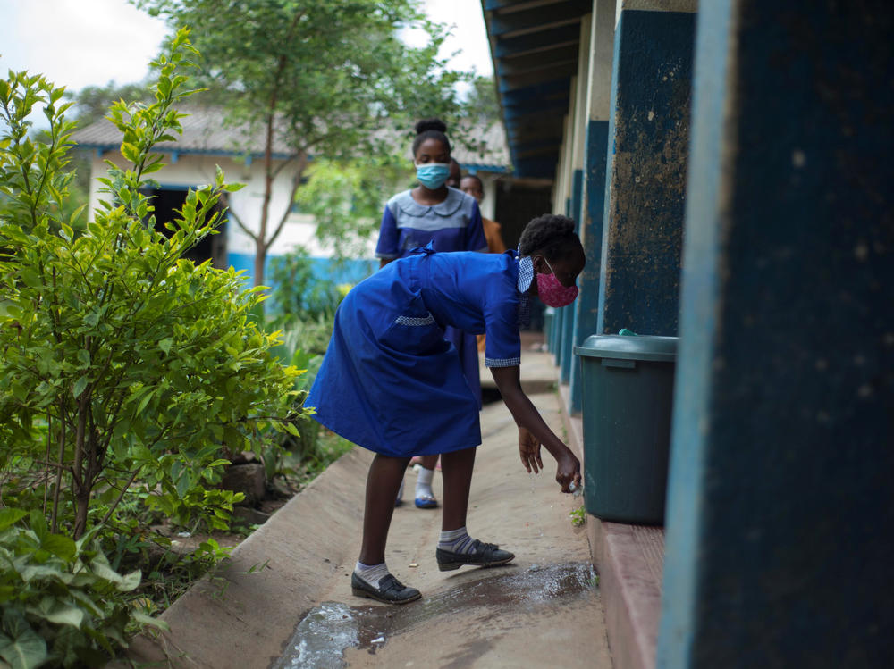 A student washes her hands before entering a classroom at a school in Blantyre, Malawi, in March 2021. Top scientists say that many African countries, including Malawi, appear to have already arrived at a substantially less threatening stage of the coronavirus pandemic.