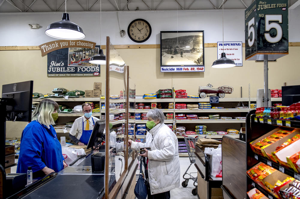A customer pays for her groceries at Jim's Jubilee Foods in Ishpeming, Mich. on March 3, 2021. Influences of the Suicide Hill Ski Bowl can be seen throughout the town of Ishpeming, such as at the grocery store, restaurants and murals on the underpasses.