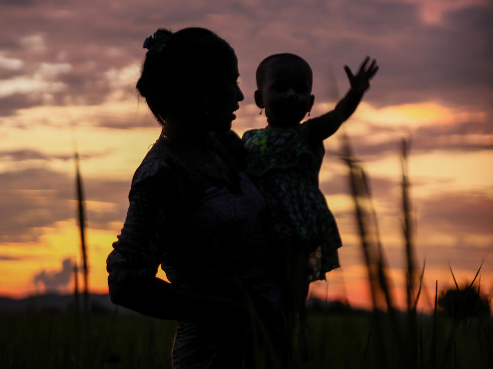 A silhouette of a mother and child from the film <em>Midwives</em>.