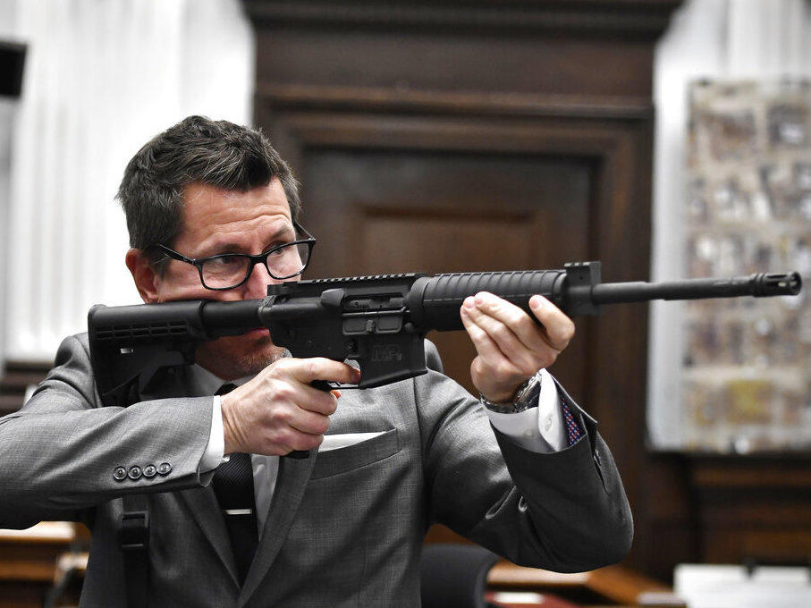 Assistant District Attorney Thomas Binger holds Kyle Rittenhouse's gun as he gives the state's closing argument in Kyle Rittenhouse's trial at the Kenosha County Courthouse in Kenosha, Wis., on Monday, Nov. 15, 2021.