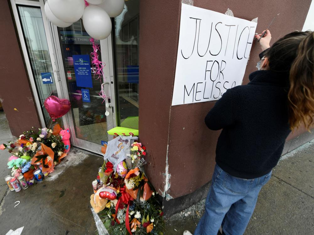 Karla Chavez, of the social activist group Chiactivists, puts up a sign at a memorial for 8-year-old Melissa Ortega in Chicago on Jan, 24. Ortega was walking with her mother in Chicago's Little Village neighborhood on Jan. 22 when she was struck by stray bullets after an unknown offender shot multiple times in their direction.