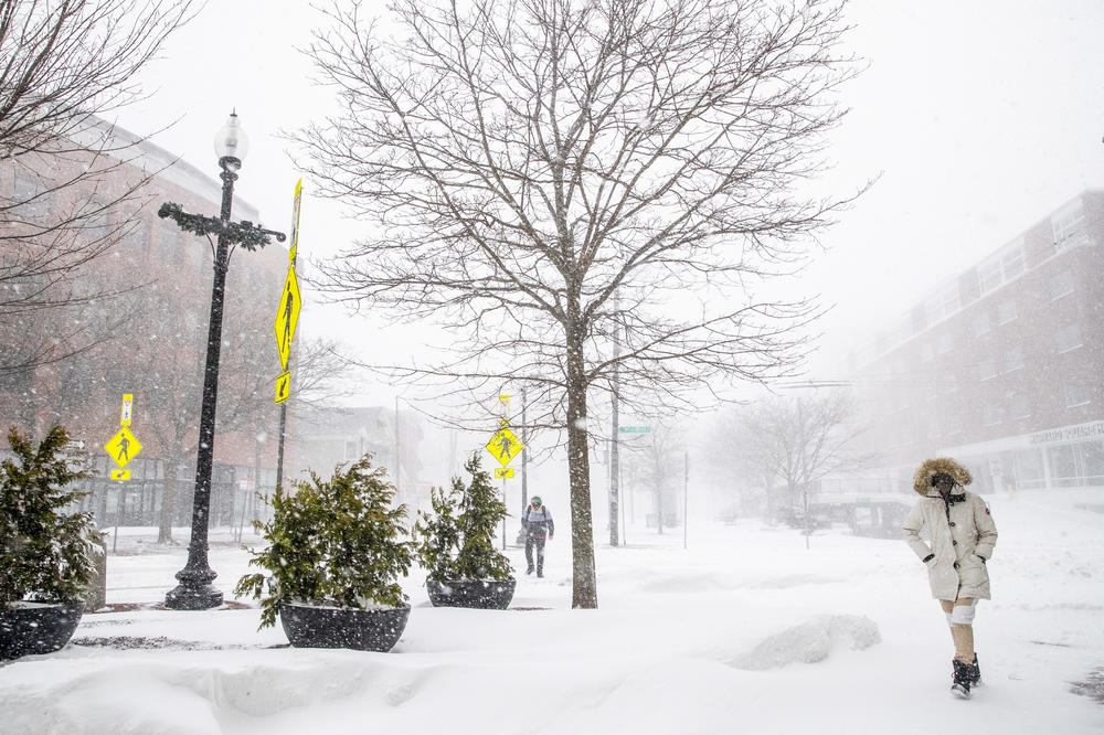 People walk through the snow in Harvard Square on Saturday in Cambridge, Mass. A powerful winter storm dumped more than a foot of snow in states across the Northeast.