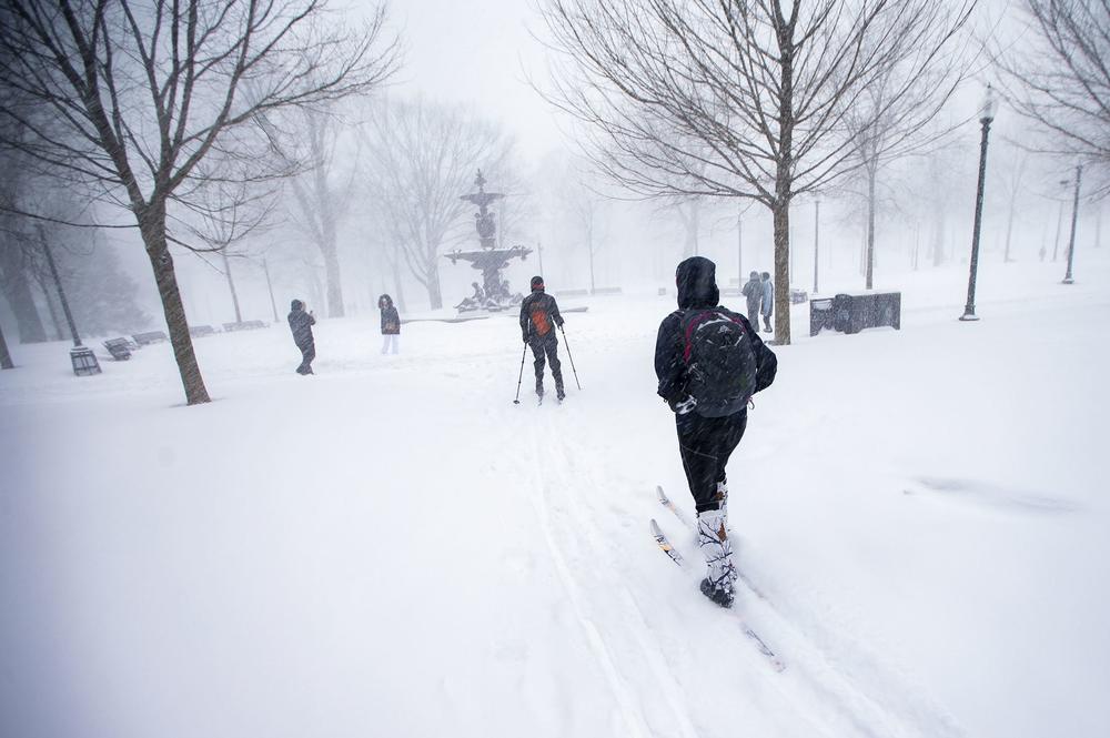 Two cross-country skiers ski towards Brewer Fountain in the Boston Common during the storm.