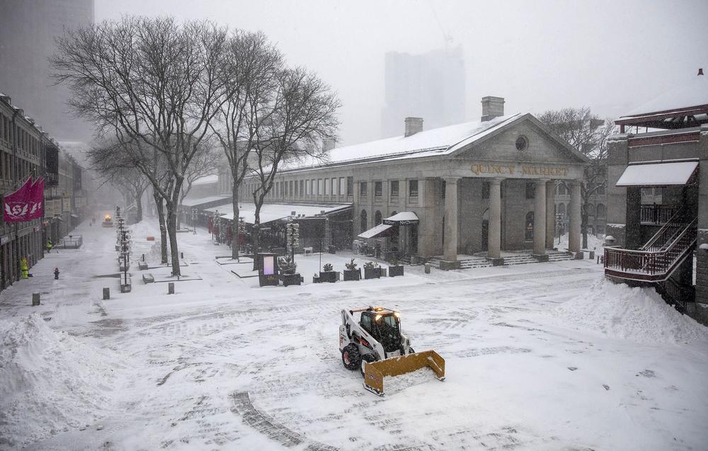 A snow plow clears snow from around Quincy Market early in the storm.