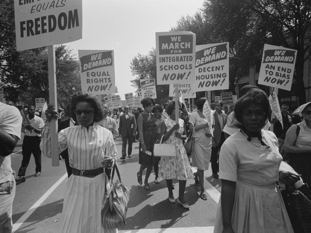 At the March on Washington on Aug. 28, 1963, African Americans carry placards demanding equal rights, integrated schools, decent housing and an end to bias.