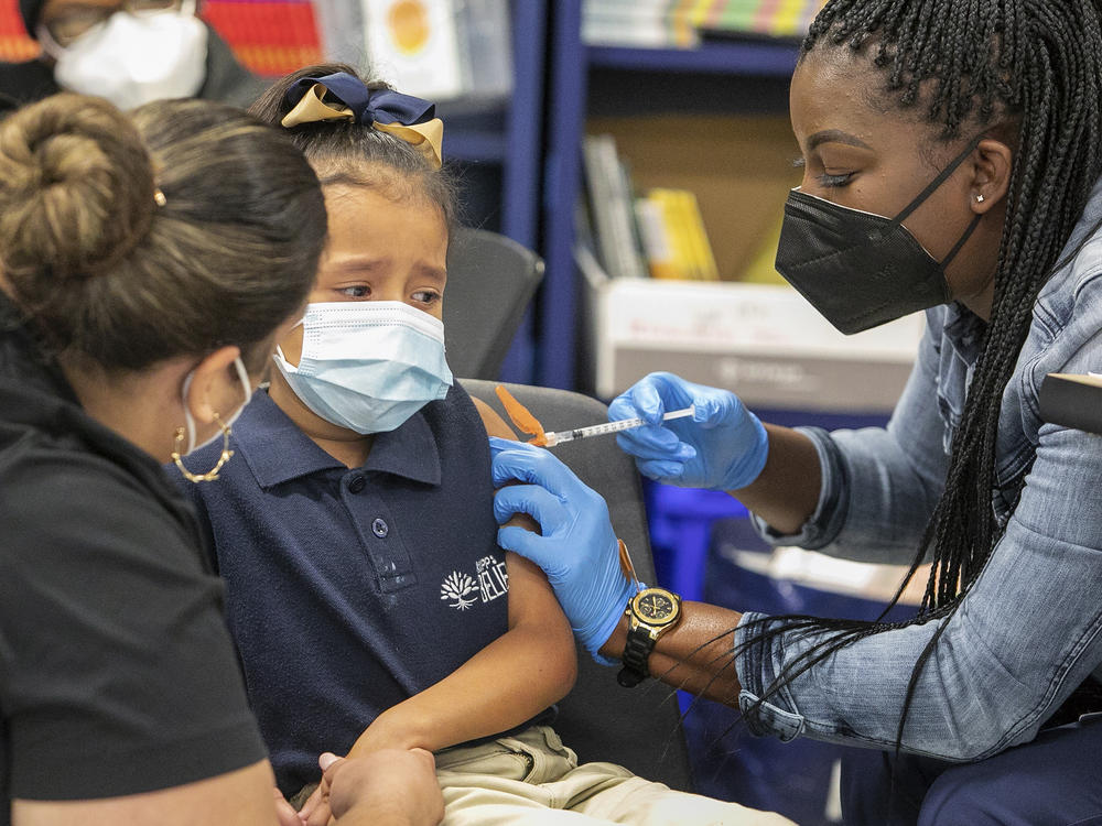 Sandra Castro vaccinates first-grader Kristen Cruz, 6, at KIPP Believe Charter School in New Orleans last week ahead of Tuesday's deadline for all students in the city's school system to be vaccinated.