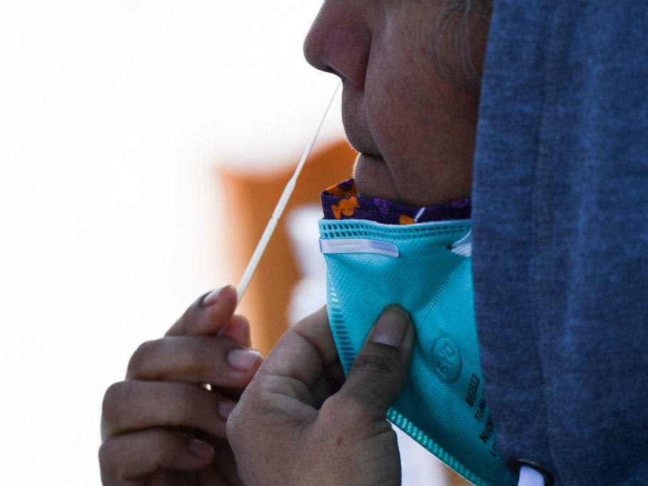 A person swabs their nose as they receive testing for both rapid antigen and PCR COVID-19 tests at a Reliant Health Services testing site in Hawthorne, Calif., on Jan. 18.