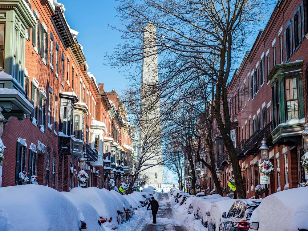 A person shovels out homes and cars near the Bunker Hill Monument in Boston, Mass., on Sunday. Blinding snow whipped up by powerful winds pummeled the eastern United States into the early hours Sunday as one of the strongest winter storms in years triggered transport chaos and power outages across a region of some 70 million people.