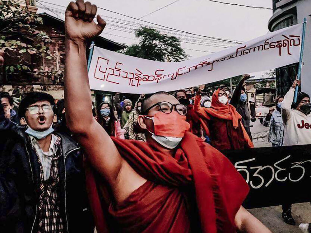 A Buddhist monk raises his clenched fist while marching during an anti-military government protest rally on Tuesday, Feb. 1 in Mandalay, Myanmar. The new U.N. special envoy for Myanmar says violence has intensified since the military took power a year ago and sparked a resistance movement in the country.