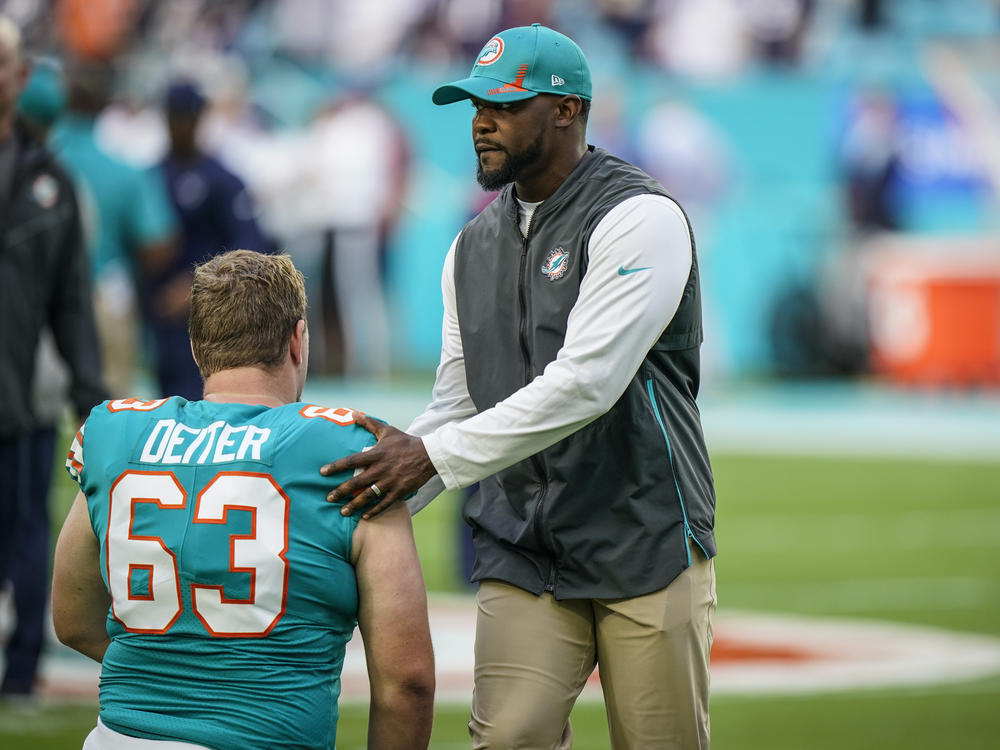 Then-head coach Brian Flores talks with Miami Dolphins center Michael Deiter before the start of their game against the Patriots on Jan. 9.