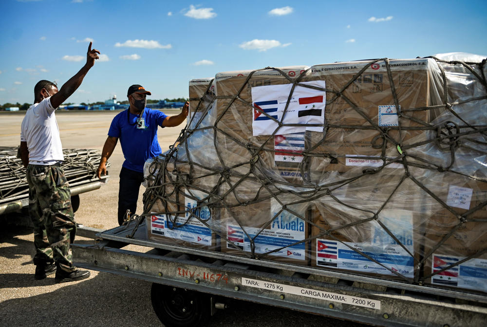 Workers at Havana's airport prepare a shipment of a Cuban COVID-19 vaccine. The government is donating the doses to Syria.