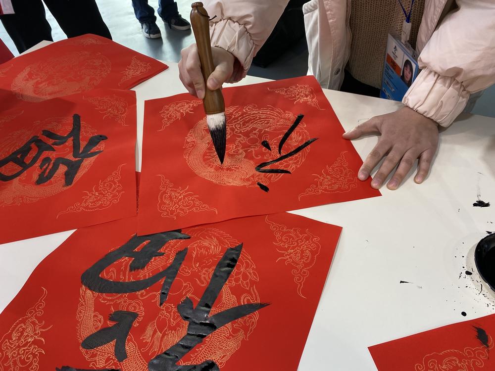 At the Main Media Center, the central hub for press, volunteers offered passersby the opportunity to paint calligraphy onto traditional New Year couplets.