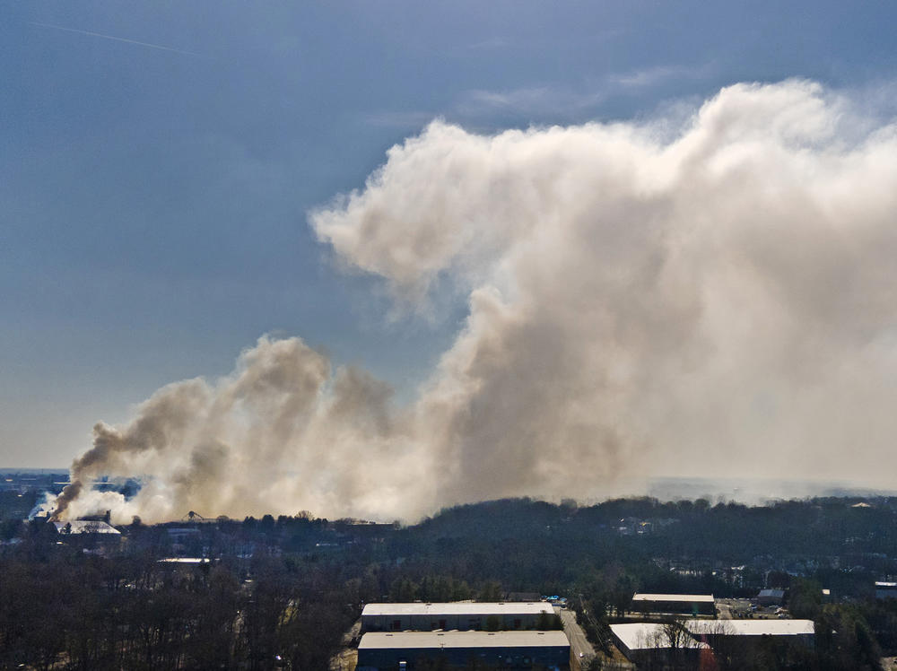 A plume of smoke from the Winston Weaver Co. fertilizer plant fire drifts west on Tuesday in Winston-Salem, N.C. The uncontrolled fire at the fertilizer plant has forced thousands of people to evacuate the area around the plant.