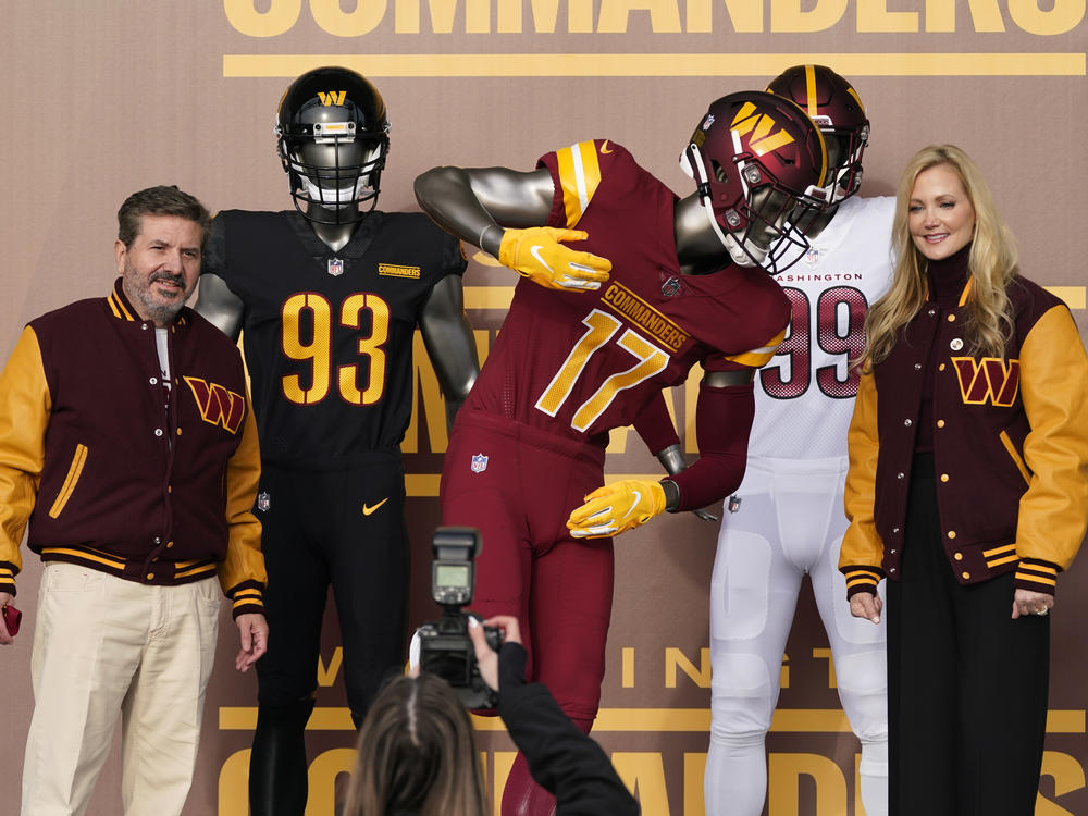 Dan, left, and Tanya Snyder, co-owner and co-CEOs of the Washington Commanders, pose for photos after unveiling their NFL football team's new identity, on Wednesday. The new name comes 18 months after the once-storied franchise dropped its old moniker following decades of criticism that it was offensive to American Indians.