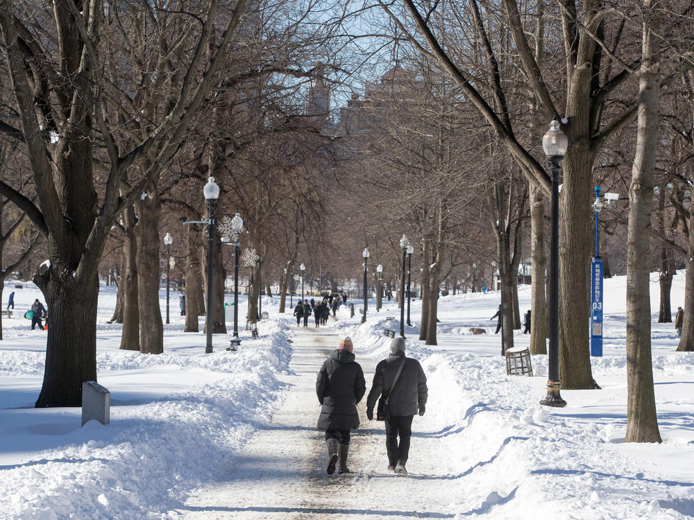 People walk on Boston Common in Boston after a snowstorm on Sunday. A powerful nor'easter last weekend brought blinding blizzard conditions with high winds causing widespread power outages to much of the Mid-Atlantic and New England coast. The storm dropped more than 30 inches in some areas of Massachusetts.