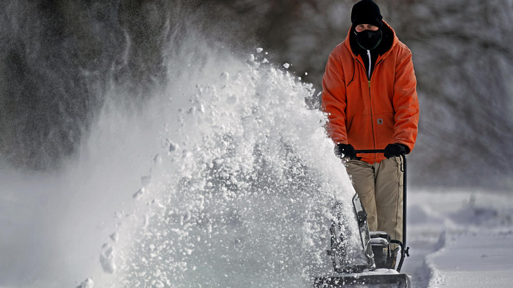 John Tapko clears snow at his house Wednesday in Overland Park, Kan.