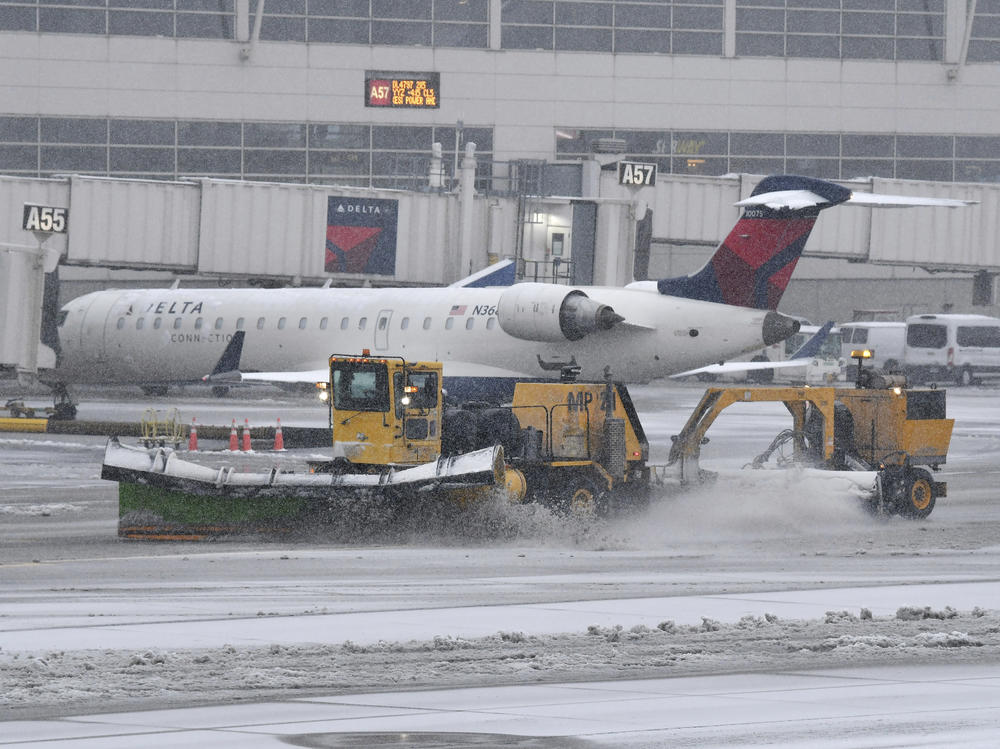 A plow clears away snow at Detroit Metropolitan Wayne County Airport in Romulus, Mich., on Wednesday.