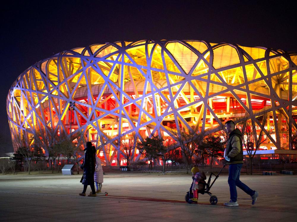 People walk past the Birds Nest stadium in Beijing on Feb. 4, 2021. Exactly a year later, it is hosting the opening ceremony for the 2022 Winter Olympics.
