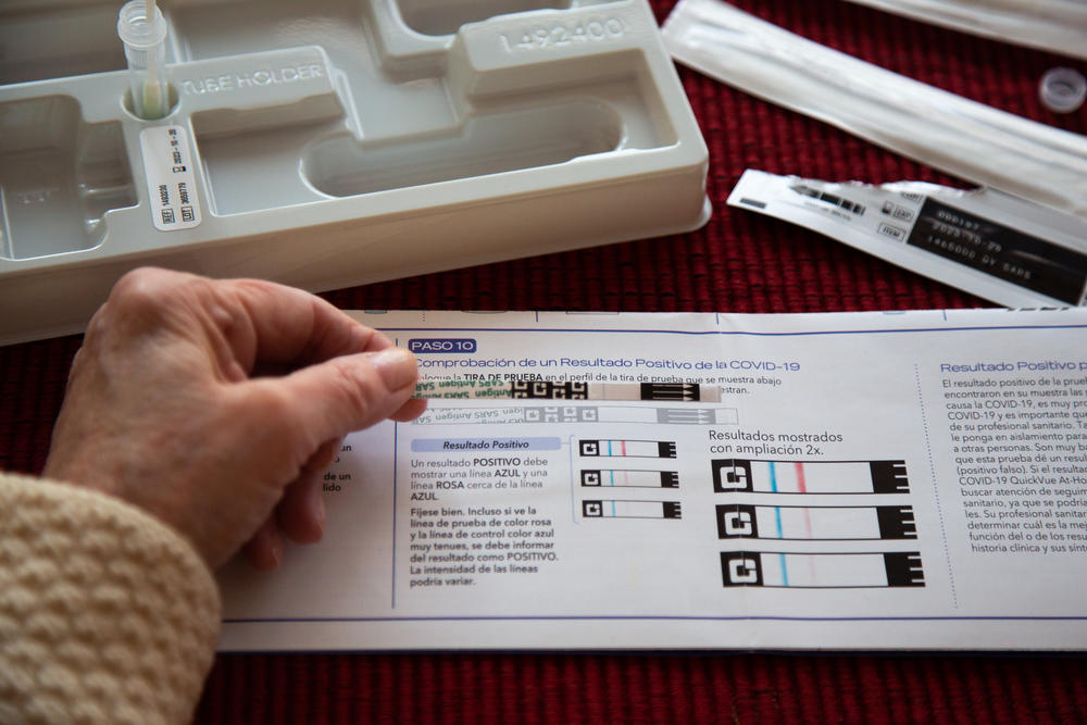 A woman compares the results of her rapid at-home antigen test to a guide provided in the testing kit on January 3, 2021.