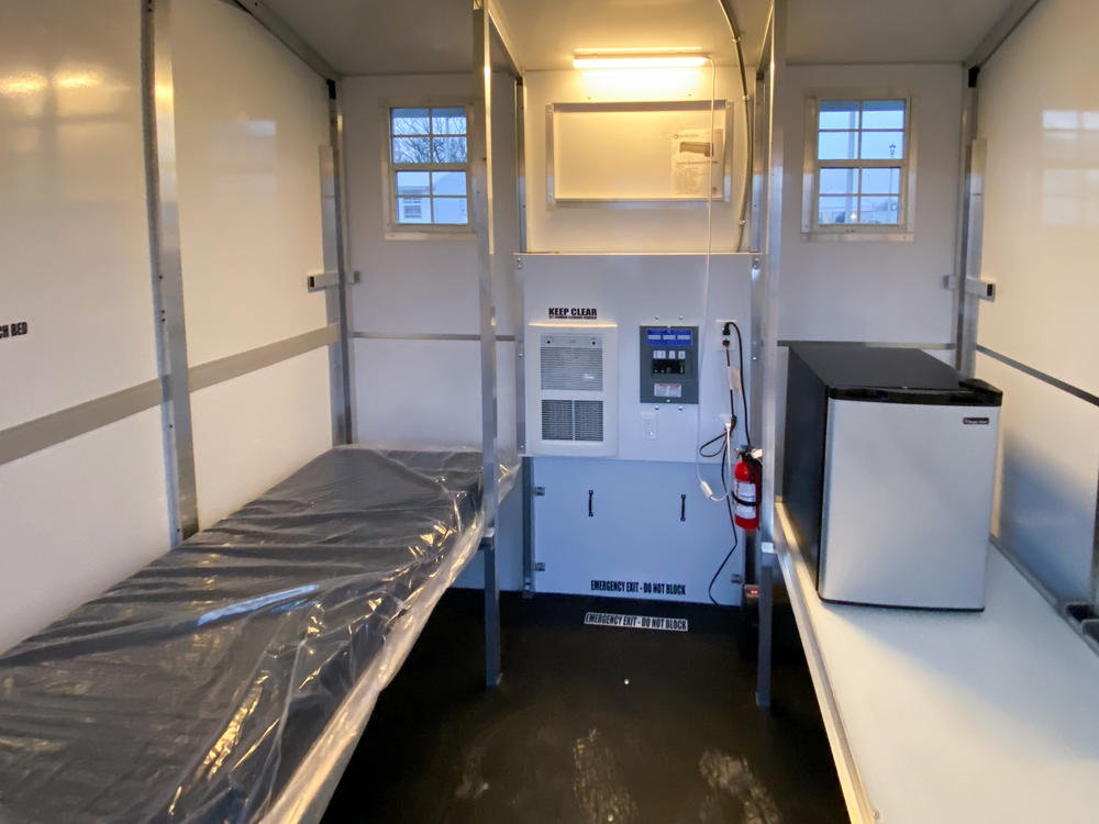 These 8-foot-by-8-foot prefabricated shelters in a tiny home village on the outskirts of Madison, Wisconsin in December, 2021 have room for a cot, a refrigerator, and some personal belongings.