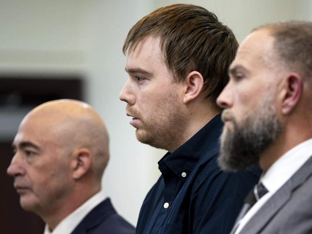Flanked by his lawyers, Travis Reinking, reacts as the verdict is read during his murder trial Friday in Nashville, Tenn. A jury found Reinking guilty of first-degree murder in the deaths of four people at a Waffle House in 2018.