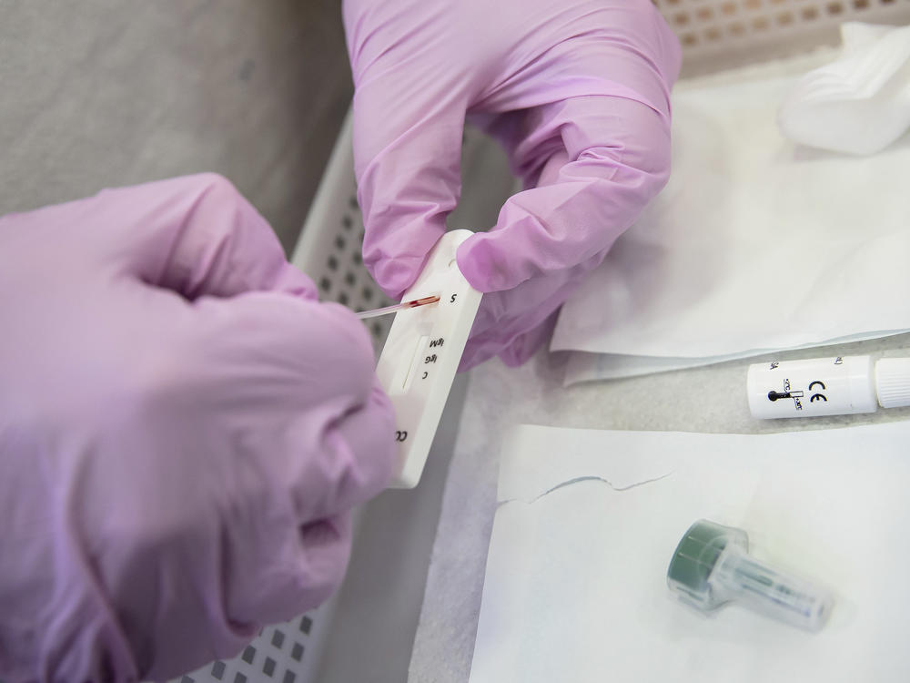 Antibody tests are becoming more available at drugstores, but what do the results <em>really</em> tell you? Above: A Paris pharmacist deposits a blood sample for a COVID-19 antibody test.
