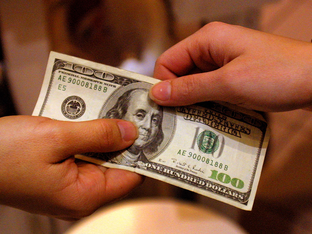 A shopper pays with cash back in 2000 in Austin, Texas. Such transactions are less and less common and are likely to become more so if the Federal Reserve adopts a digital version of the dollar.