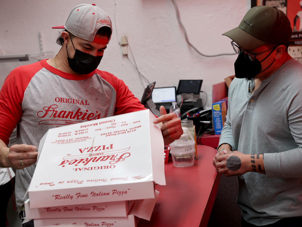A worker rings up an order at Frankie's Pizza on Jan. 12 in Miami, Fl. The labor market is getting healthier, but much will depend on the progress of the pandemic, which can easily sway demand for workers — especially at businesses that rely on in-person contact with customers.