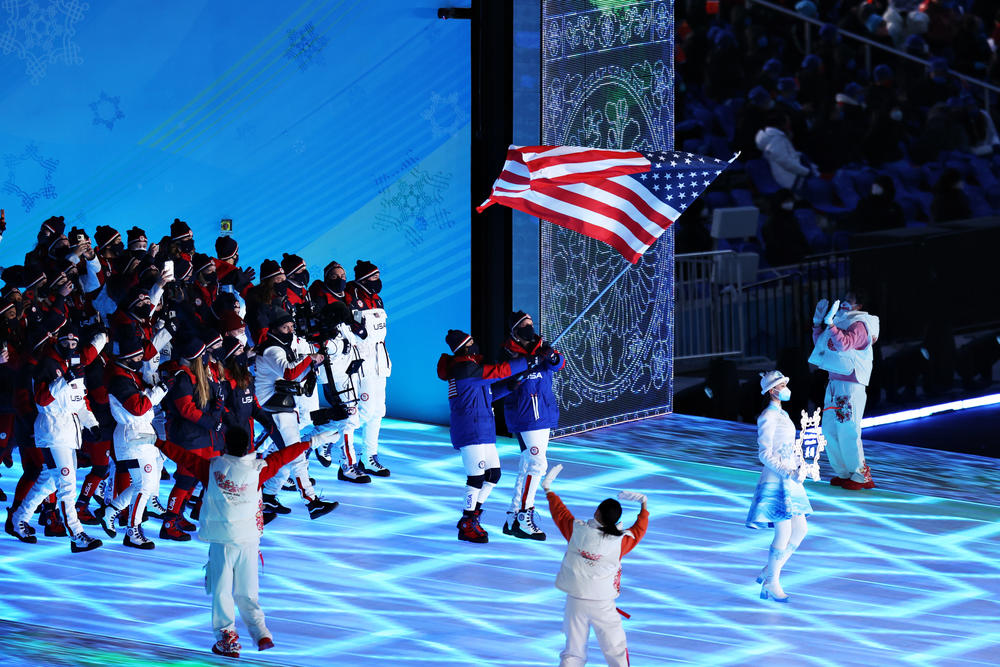 Flag bearers Brittany Bowe and John Shuster lead Team USA during the opening ceremony.