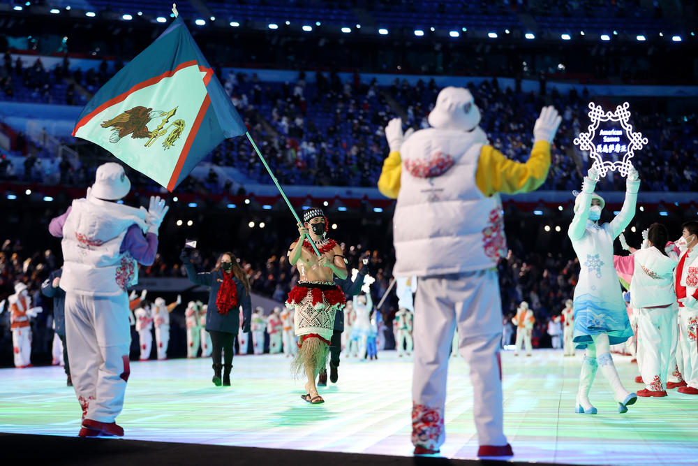 Flag bearer Nathan Crumpton of Team American Samoa marches during the parade of athletes at the opening ceremony.