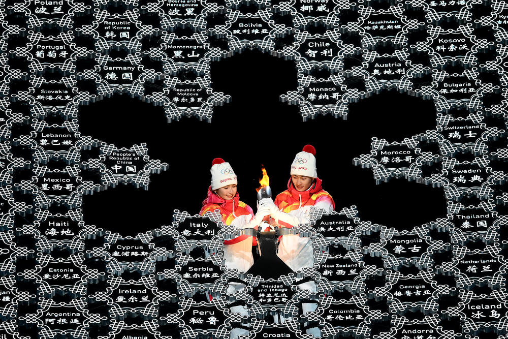 Torch bearers light the Olympic cauldron during the opening ceremony in Beijing.