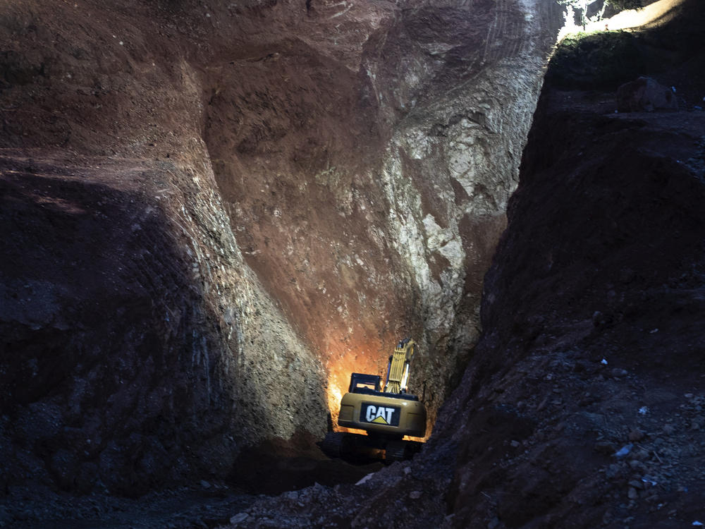Heavy equipment is used to dig through a mountain on Friday during an attempt to rescue a boy trapped in a well.