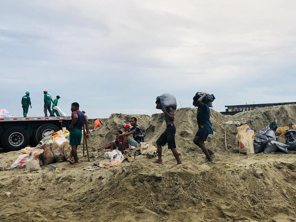 People make their way home during bad weather in Tamatave, Madagascar, Feb. 5, 2022.