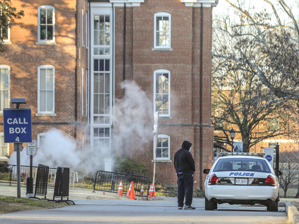 A man speaks with a police officer in a patrol vehicle outside the Spelman campus earlier this month after 17 historically Black colleges received bomb threats.
