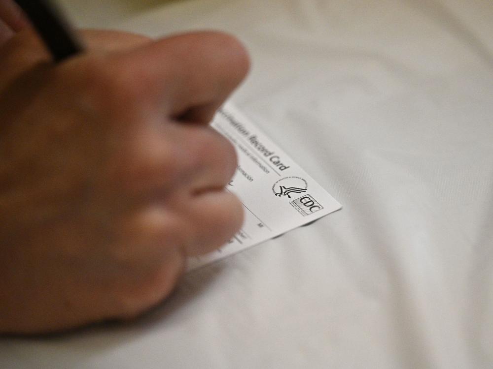 A nurse fills out a vaccine card at an L.A. Care Health Plan vaccination clinic at Los Angeles Mission College.