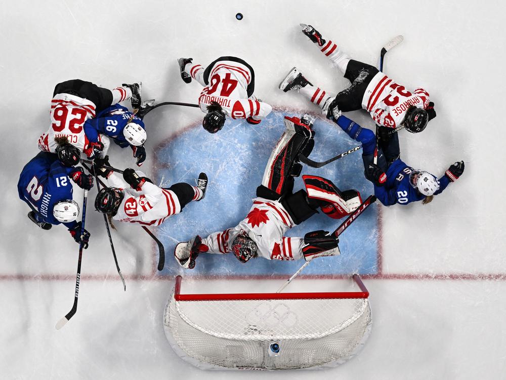 Canada's goaltender Ann-Renee Desbiens (center) tries to save the goal during Tuesday's group play match between the U.S. and Canada at the Beijing Games.