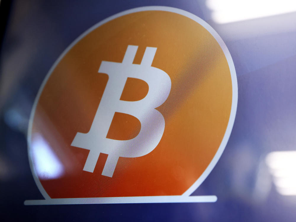 The Bitcoin logo is displayed on the screen of a Bitcoin ATM in Los Angeles. The Justice Department said a New York couple has been charged with conspiring to launder billions of dollars' worth of stolen bitcoin.