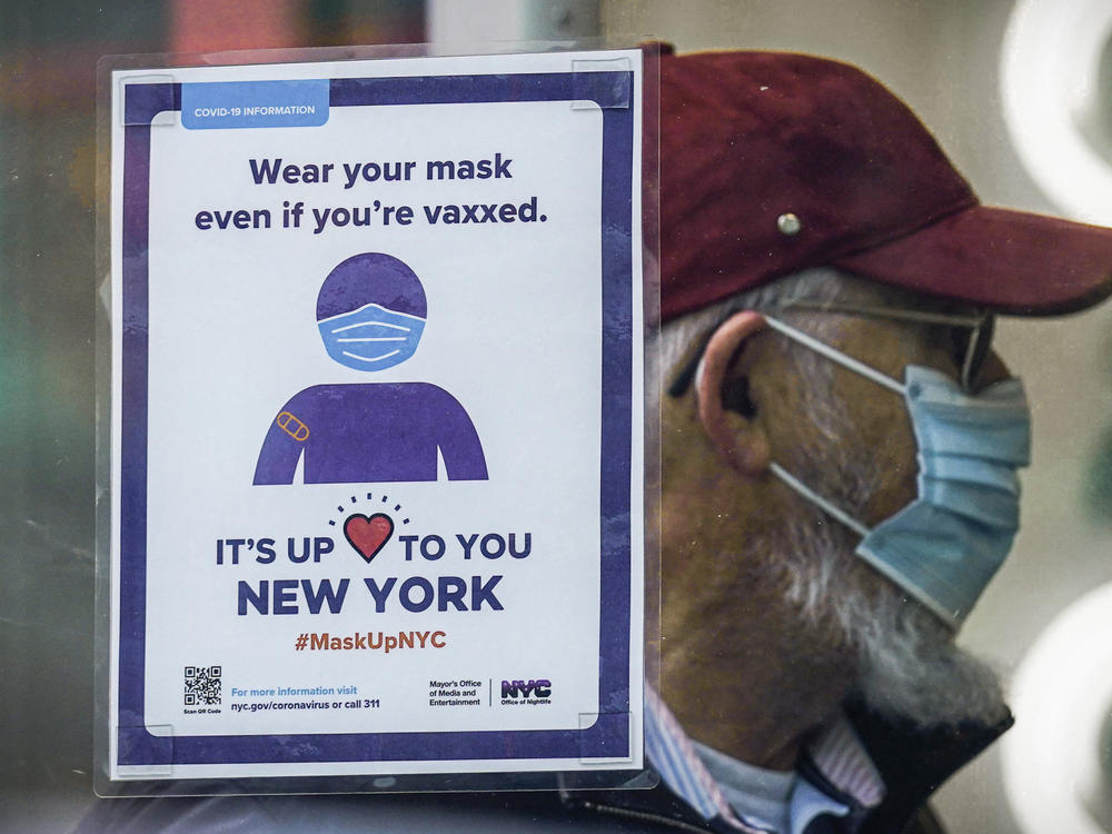 A sign reminds customers that masks are required in their store in New York in December. A growing number of states are lifting their indoor mask mandates in the coming weeks.