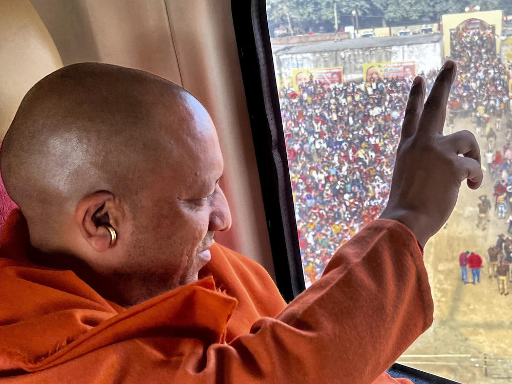 Uttar Pradesh Chief Minister Yogi Adityanath flashes a victory sign to the crowd from a helicopter as he leaves after an election rally ahead of state elections in Muradabad, India, Tuesday, Feb.8, 2022.