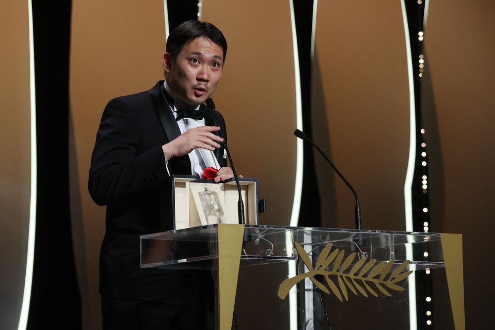 Japanese director Ryusuke Hamaguchi delivers a speech after receiving the best screenplay award for <em>Drive My Car</em> at the 2021 Cannes Film Festival in France.