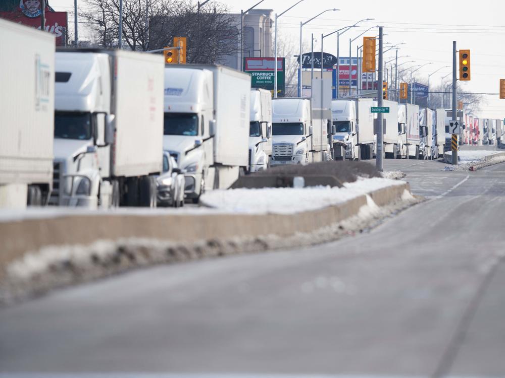 A line of trucks waits for the road to the Ambassador Bridge border crossing in Windsor, Ontario, to reopen February 8  after protesters blocked the road Monday.