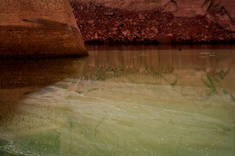 Water sparkles on a shrinking Lake Powell near the Cathedral in the Desert monument in Glen Canyon.