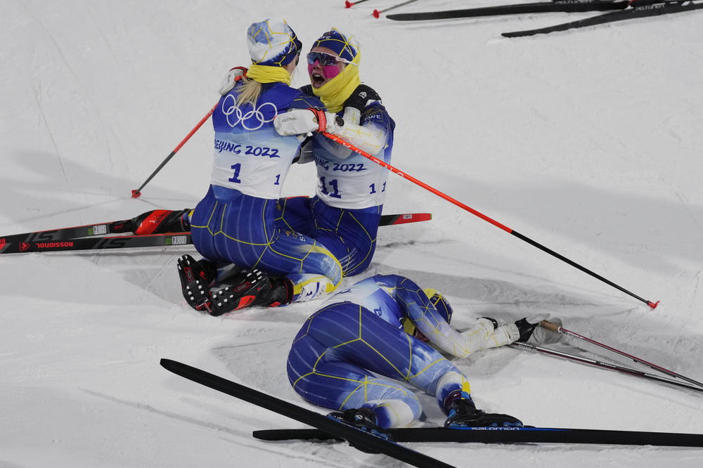 Gold medal finisher Jonna Sundling, of Sweden, left, celebrates with teammate Emma Ribom as silver medal finisher Maja Dahlqvist, of Sweden, right, reacts after the women's sprint free cross-country skiing competition at the 2022 Winter Olympics, Tuesday, Feb. 8, 2022, in Zhangjiakou, China.