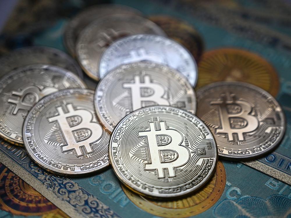 This illustration photograph taken on July 19, 2021 in Istanbul shows a physical banknote and coin imitations of the Bitcoin crypto currency. (Photo by Ozan KOSE / AFP) (Photo by OZAN KOSE/AFP via Getty Images)
